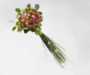 Tæt brudebuket med ranunkler og græsskaft